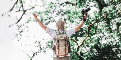 Aziatisch reiziger Mens met rugzak Holding een camera en maken een gelukkig gebaar foto