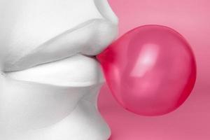 detailopname van een lip in viva magenta met een roze bubbel gom. gips elementen in een modern stijl. creatief foto