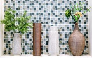 sier- planten in verschillend vazen zetten Aan wit plank voorkant van plein patroon tegel in de toilet. foto