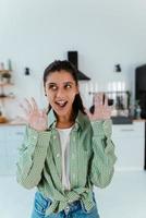 jong vrouw shows haar handen in meel in de keuken foto