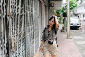 jong Aziatisch vrouw rugzak reiziger genieten van straat cultureel lokaal plaats en glimlach. reiziger controle uit kant straten. foto