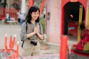 portret van Aziatisch vrouw gezegde gebeden en ogen dichtbij in voorkant van lokaal Chinese altaar in Bangkok, Thailand foto