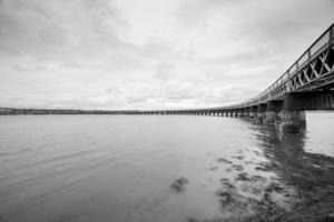 dundee zeegezicht spoorbrug en water met bewolkt lucht foto