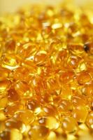 stapel van gouden capsules van vitamine d3 Aan een geel achtergrond met vrij ruimte foto