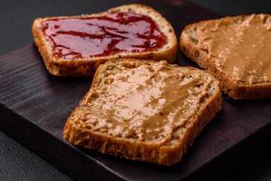 voedzaam boterhammen bestaande van brood, framboos jam en pinda boter foto