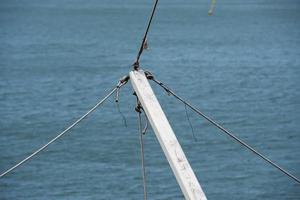 hout wit werf met touwen Aan blauw zee achtergrond foto