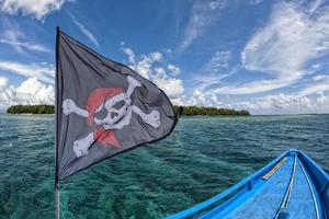 golvend piraat vlag vrolijk roger Aan tropisch eiland achtergrond foto