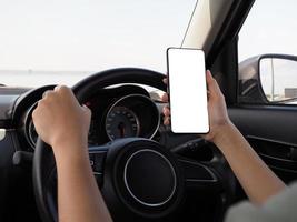 hand- van een meisje gebruik makend van een telefoon terwijl het rijden een auto. foto