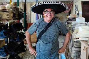 toerist met Mexicaans sombrero koe jongen hoed winkel foto