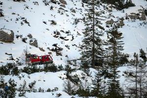 rood bijgehouden sneeuwscooter detail beklimming fans berg in dolomieten Aan wit sneeuw foto