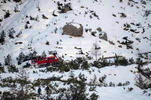 rood bijgehouden sneeuwscooter detail beklimming fans berg in dolomieten Aan wit sneeuw foto