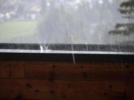 hagelbui Aan balkon in berg hagelstenen terwijl vallend foto