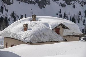 huis hut gedekt door sneeuw in dolomieten foto