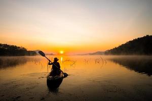 Dames Aan kajak rijen in de reservoir gedurende de zonsopkomst, harak Woud park huai naam Mens reservoir loei Thailand 21 jan 2023 foto