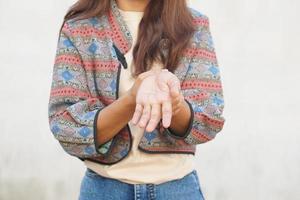 Aziatisch vrouw hebben spier zwakheid in haar handen foto