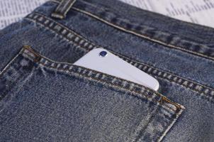 smartphone in een zak- van blauw jeans foto