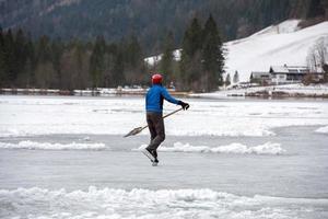 mensen spelen hockey Aan bevroren meer foto