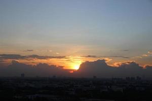 zonsondergang donker blauw wolk met wit gouden licht lucht achtergrond en stad licht middernacht avond tijd foto