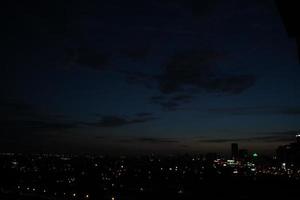 donker blauw wolk met wit licht lucht achtergrond en stad licht middernacht avond tijd foto