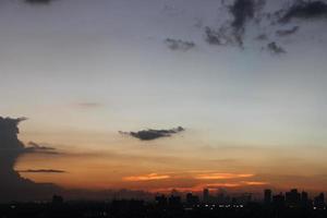 zonsondergang donker blauw wolk met wit gouden licht lucht achtergrond en stad licht middernacht avond tijd foto