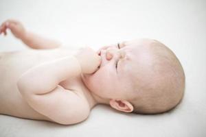 schattige babymeisje huilen op bed foto