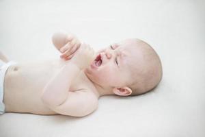 schattige babymeisje huilen op bed foto