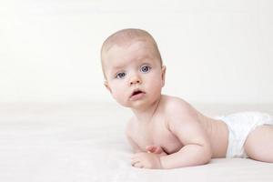 schattige babymeisje liggend op bed foto