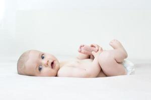 schattige babymeisje liggend op bed foto