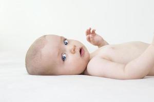 schattige babymeisje liggend op bed foto