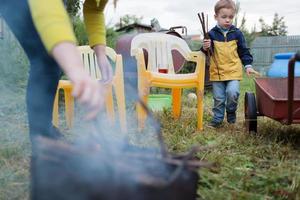 moeder en zoon beginnen een vuur in de tuin foto