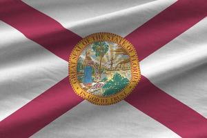 Florida ons staat vlag met groot vouwen golvend dichtbij omhoog onder de studio licht binnenshuis. de officieel symbolen en kleuren in banier foto