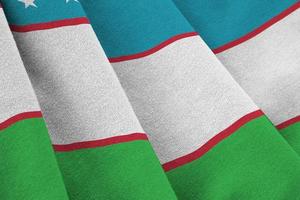 Oezbekistan vlag met groot vouwen golvend dichtbij omhoog onder de studio licht binnenshuis. de officieel symbolen en kleuren in banier foto