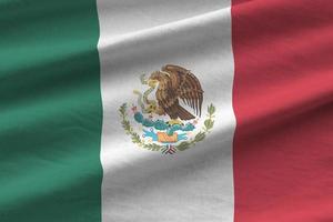 Mexico vlag met groot vouwen golvend dichtbij omhoog onder de studio licht binnenshuis. de officieel symbolen en kleuren in banier foto