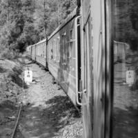 shimla, himachal pradesh, india - 14 mei 2022 - speelgoedtrein kalka-shimla route, bewegend op de spoorlijn naar de heuvel, speelgoedtrein van kalka naar shimla in india tussen groen natuurlijk bos foto