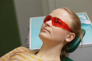 vrouw in rode veiligheidsbril in een tandartspraktijk foto