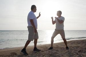 twee mannen trainen op een strand foto
