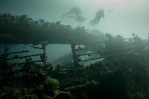 scuba verschillend verkennen een schip wrak in rood zee foto