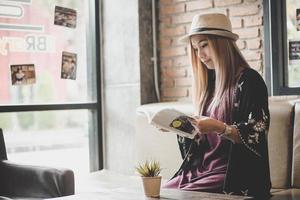 gelukkig zakenvrouw leesboek terwijl u ontspant in café foto