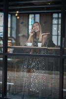 jonge vrouwen gebruiken en kijken naar smartphone in venster café