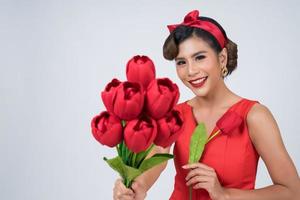 portret van een mooie vrouw met een boeket van rode tulp bloemen foto