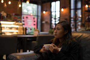 jonge vrouw ontspannen koffie drinken in café foto