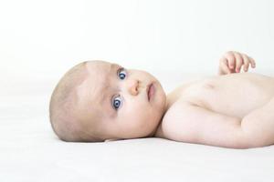 schattige babymeisje liggend op bed foto