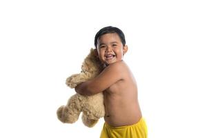 kleine Aziatische jongen met een grote teddybeer geïsoleerd op een witte achtergrond foto