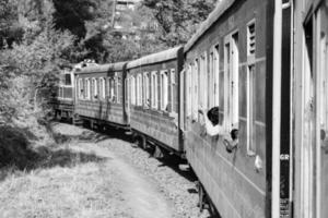 shimla, himachal pradesh, india - 14 mei 2022 - speelgoedtrein kalka-shimla route, bewegend op de spoorlijn naar de heuvel, speelgoedtrein van kalka naar shimla in india tussen groen natuurlijk bos foto