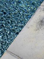 een levendig zwembad met een betonnen rand foto