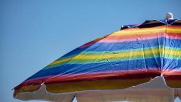 regenboog gekleurde parasol op een zonnige dag foto
