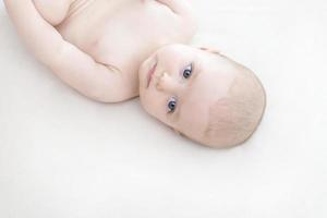 schattige babymeisje liggend op bed foto