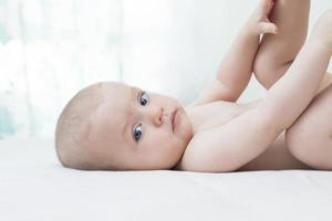 schattige babymeisje liggend op bed foto