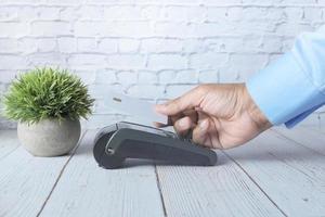 contactloos betalingsconcept met jonge man die met creditcard betaalt foto