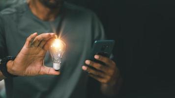 idee innovatie en inspiratie concept. hand- van Mens Holding verlichte licht lamp, concept creativiteit met bollen dat schijnen schitteren. inspiratie van ideeën voor duurzame bedrijf ontwikkeling. foto